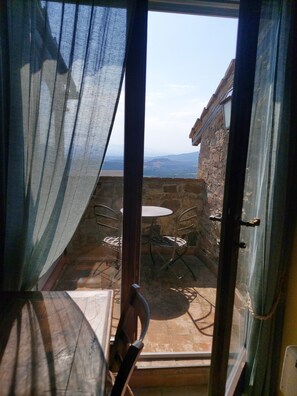 Ein Zimmer mit Blick auf ein Steingebäude, einen Tisch und zwei Stühle.