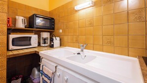 A kitchen with a white sink, a microwave, a toaster, and a coffee maker on the countertop. - Single-storey apartment for 6 people in Valras-Plage, close to the sea (Valras-Plage)