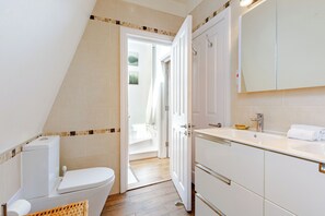 Ein Badezimmer mit Toilette, Waschbecken und Spiegel.