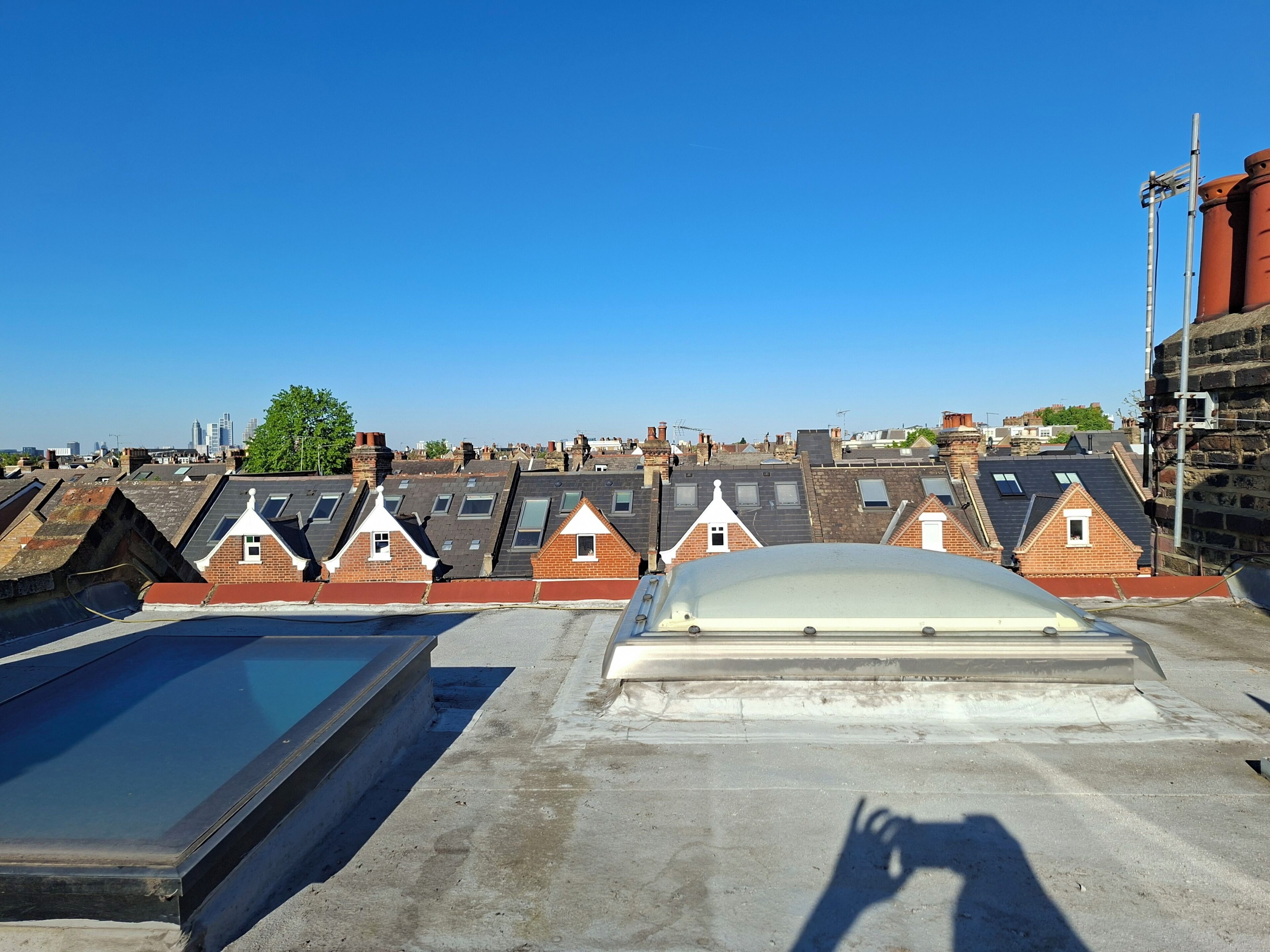 Un toit offrant une vue sur plusieurs maisons à étages, une piscine et un ciel dégagé.