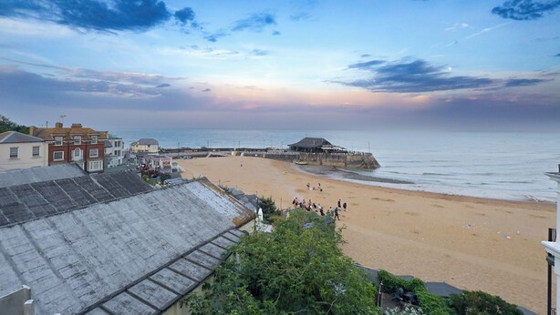 A beach with a pier, buildings, and a clear sky. - Enjoy a cosy 2-bedroom cottage-style stay in Broadstairs, just around 2 minutes from the beach and close to Viking Bay. Sleeps up to 4 guests with a double bedroom, bunk room, good Wi-Fi, comfortable living space, kitchen/dining area, washing machine (Kent)