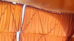 Quarto com cama, cortinas e piso espelhado.