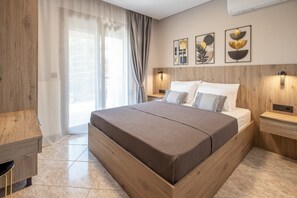 Ein modernes Schlafzimmer mit einem großen Bett, einem Holzkopfteil, zwei Nachttischen und Kunstwerken an der Wand.