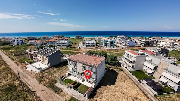 Ein Küstenwohngebiet mit modernen Gebäuden, blauem Himmel und Blick auf das Meer.