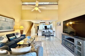 A living room with a sofa, coffee table, TV, and a dining area with chairs and a table. - VLP 57 - easy access to heated pool and amenities! (Saint Augustine)