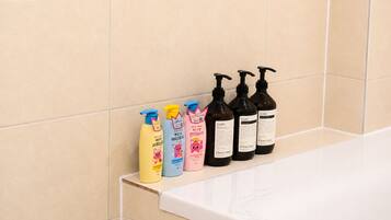 A bathroom with a shelf holding various toiletries.