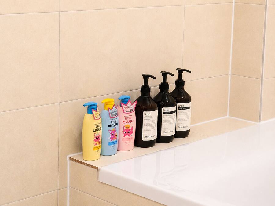 A bathroom with a shelf holding various toiletries.