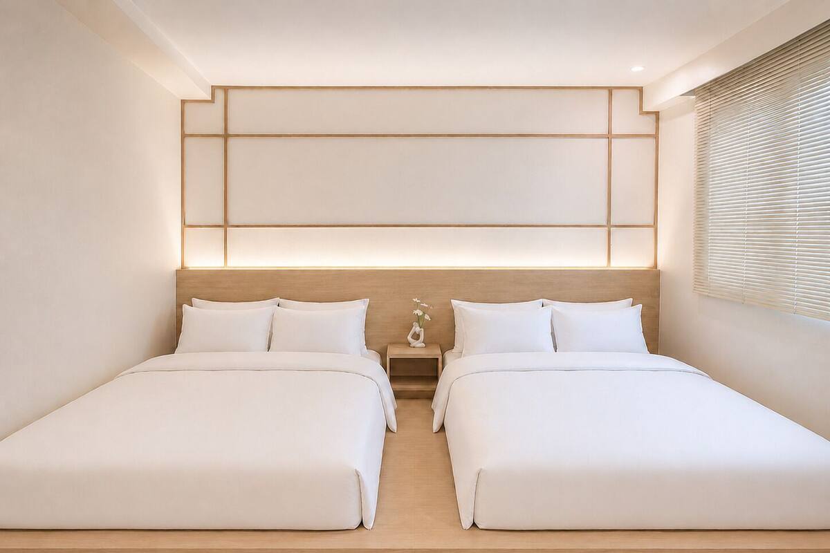 A modern hotel room with two beds, a wooden headboard, a nightstand, and a window with blinds.