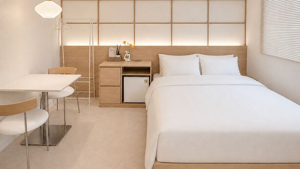 A modern hotel room with a bed, bedside table, desk, and chair. - Yoonstay Haenggung (Suwon)