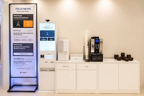 A kiosk with a user guide for KIOSK USER GUIDE, a coffee machine, and a trash bin. - Yoonstay Haenggung (Suwon)