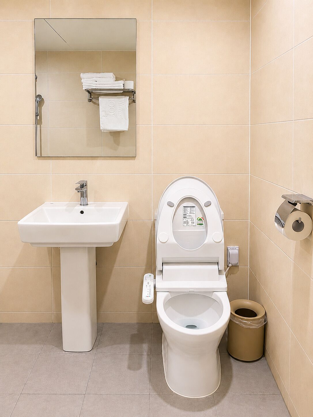 A bathroom with a white sink, toilet, and a mirror above the sink.