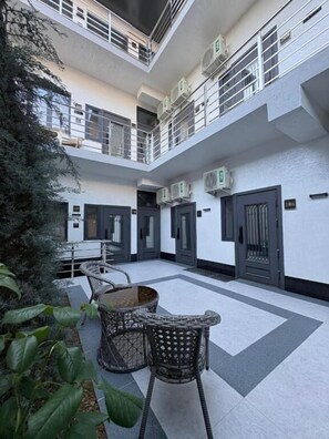 Un atrium d'altures múltiples amb una zona d'estar central, unitats de condicionament de l'aire i una escala.