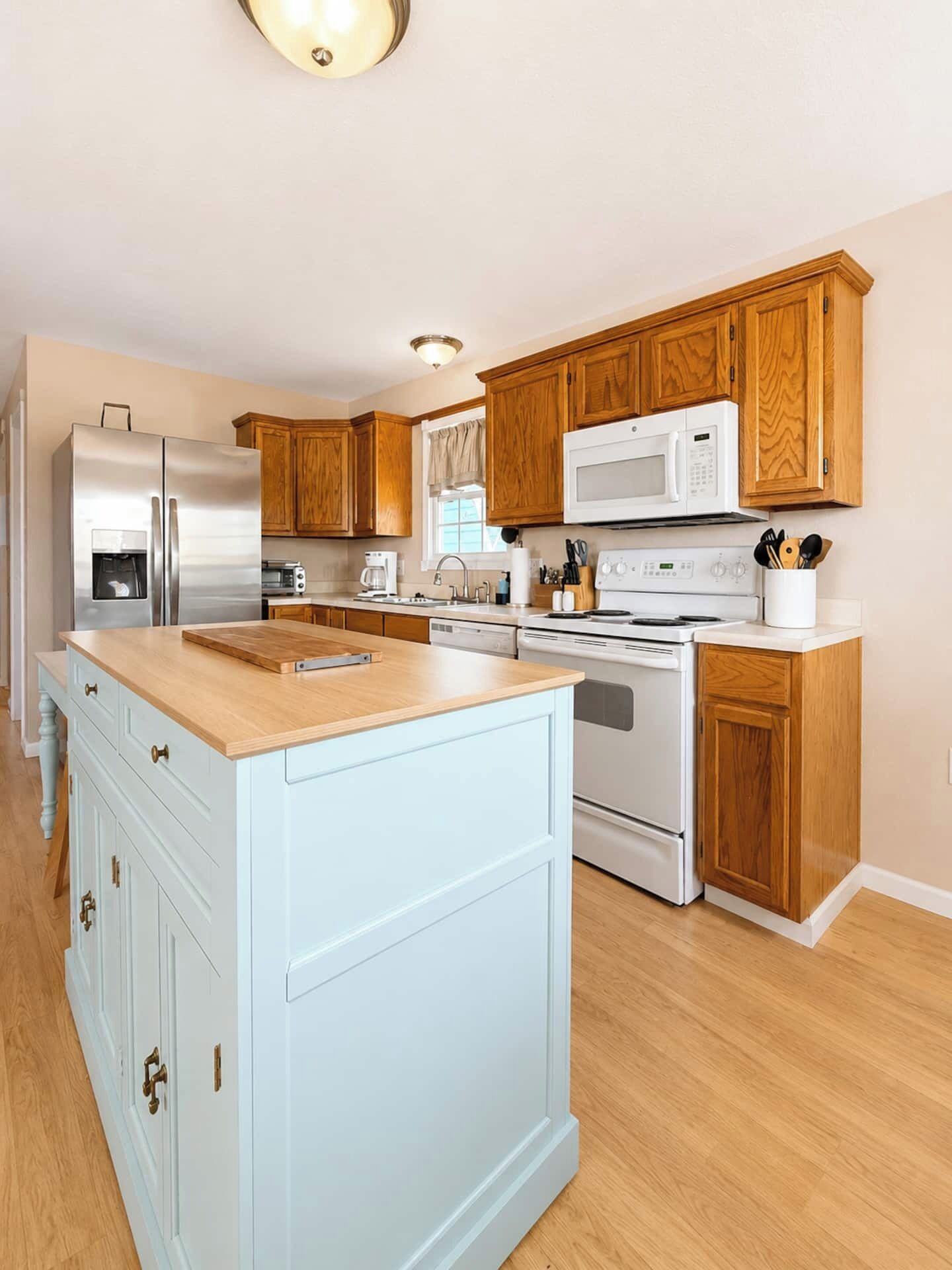 A kitchen with wooden cabinets, stainless steel appliances, and a central island.