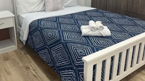 Una camera da letto con un letto, un comodino, un armadio e un quadro appeso al muro.