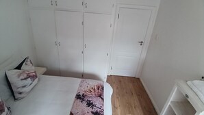 Un dormitorio con una cama, un armario y una puerta.
