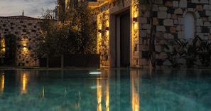 A stone building with a pool in front, surrounded by greenery. - Canata Hotel Çeşme (Cesme)