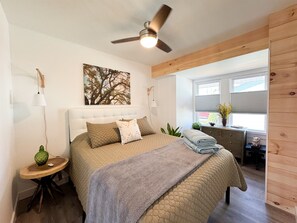 A bedroom with a bed, a ceiling fan, a window, and a plant. - The perfect APT near everything! (Rio grande)