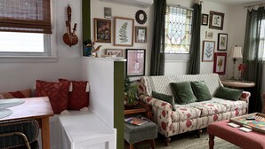 A cozy living room with a patterned sofa, a small table, and a window with curtains. - Botanical 2BR, steps to Hawk Haven, near Beaches (rio grande)