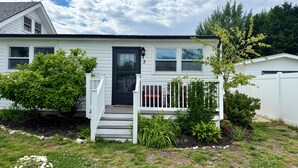 A single-story house with a front porch, a black door, and a number '3' on the door. - Botanical 2BR, steps to Hawk Haven, near Beaches (rio grande)