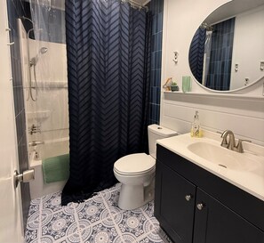 A bathroom with a shower, toilet, sink, and mirror. - Charming 2BR, steps to Hawk Haven, near Beaches (rio grande)