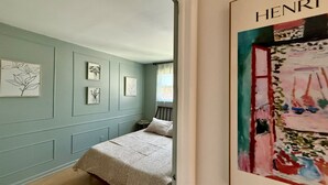 A bedroom with a bed, a small bedside table, and a window. - Botanical 2BR, steps to Hawk Haven, near Beaches (rio grande)
