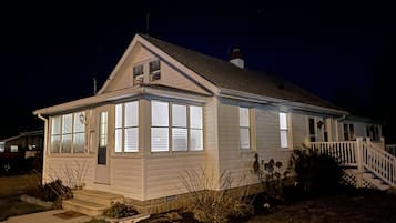 A single-story house with a porch, a chimney, and a small deck.