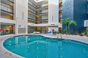 An indoor swimming pool with a clear view of the surrounding building structure, including multiple balconies and a no-lifeguard sign. - 2 Bedroom 2 Bathroom Condo - Completely Renovated Short Walk to the Beach (Hilton Head Island)