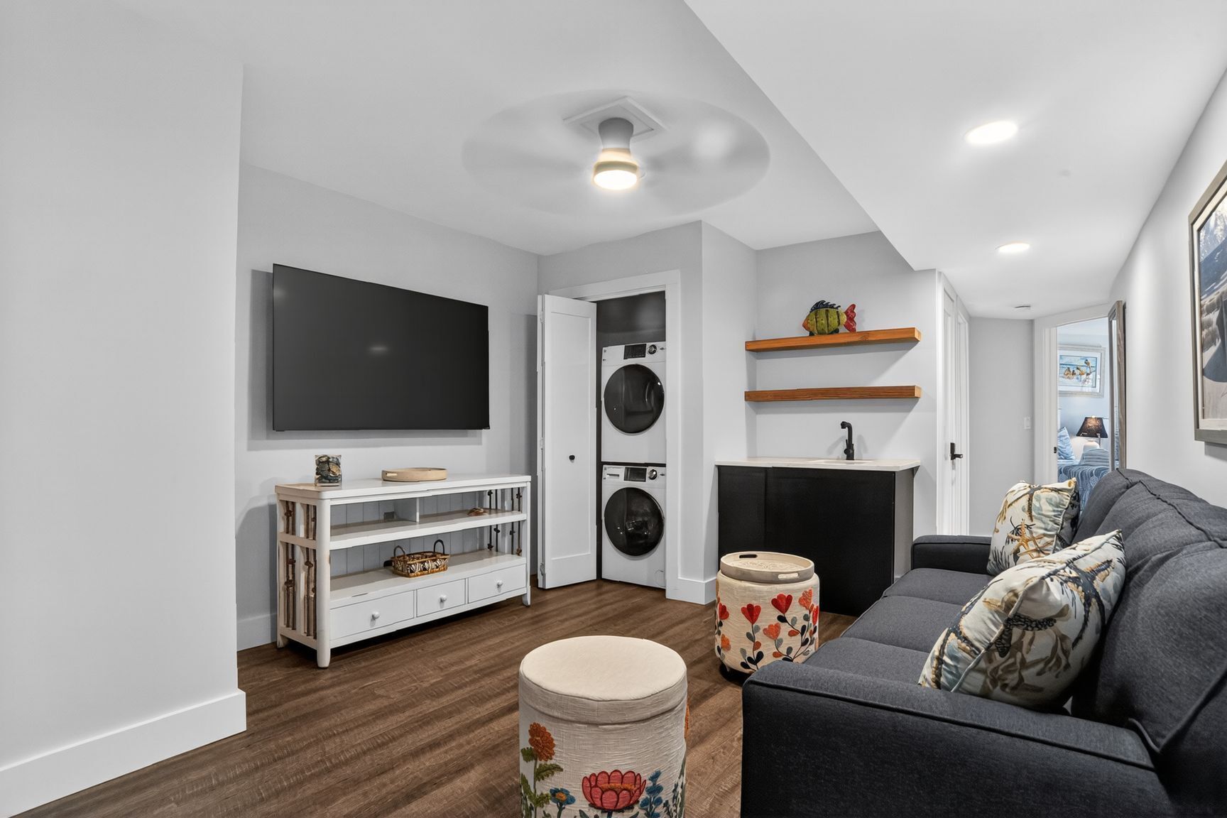 Uma sala de estar moderna com televisão de tela plana, sofá, mesa de centro, lareira e máquina de lavar.