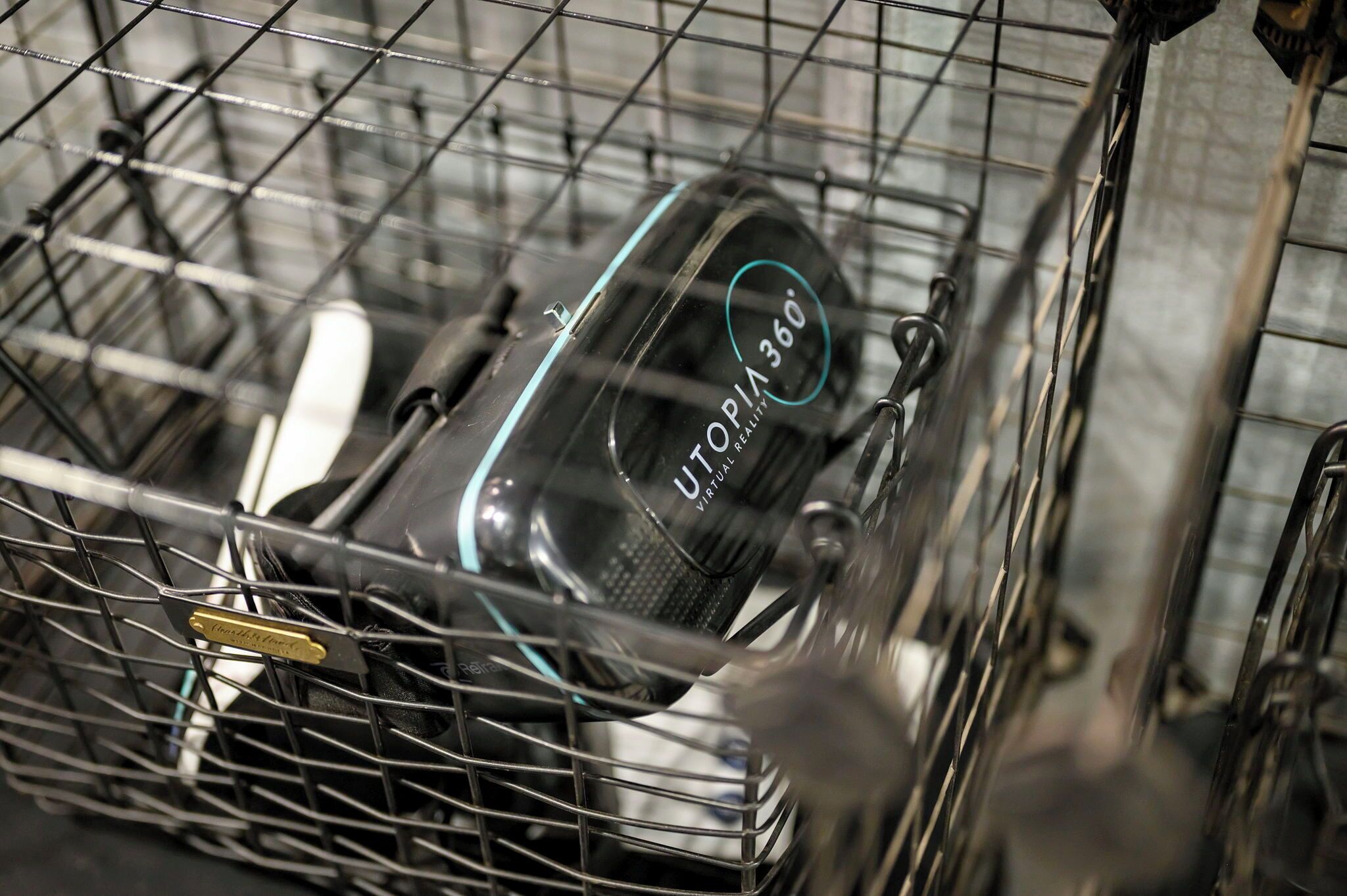 A dishwasher with a label that reads 'UTOPIA 360° VIRTUAL REALITY' inside a metal rack.