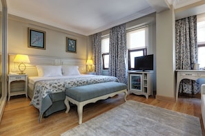 A bedroom with a bed, bedside tables, a desk, a television, and curtains. - Arena Modern Hotel (Istanbul)