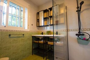A bathroom with a window, a sink, a mirror, and a shower. - Villa El Dorado – Private Oasis near the Beach (Estepona)