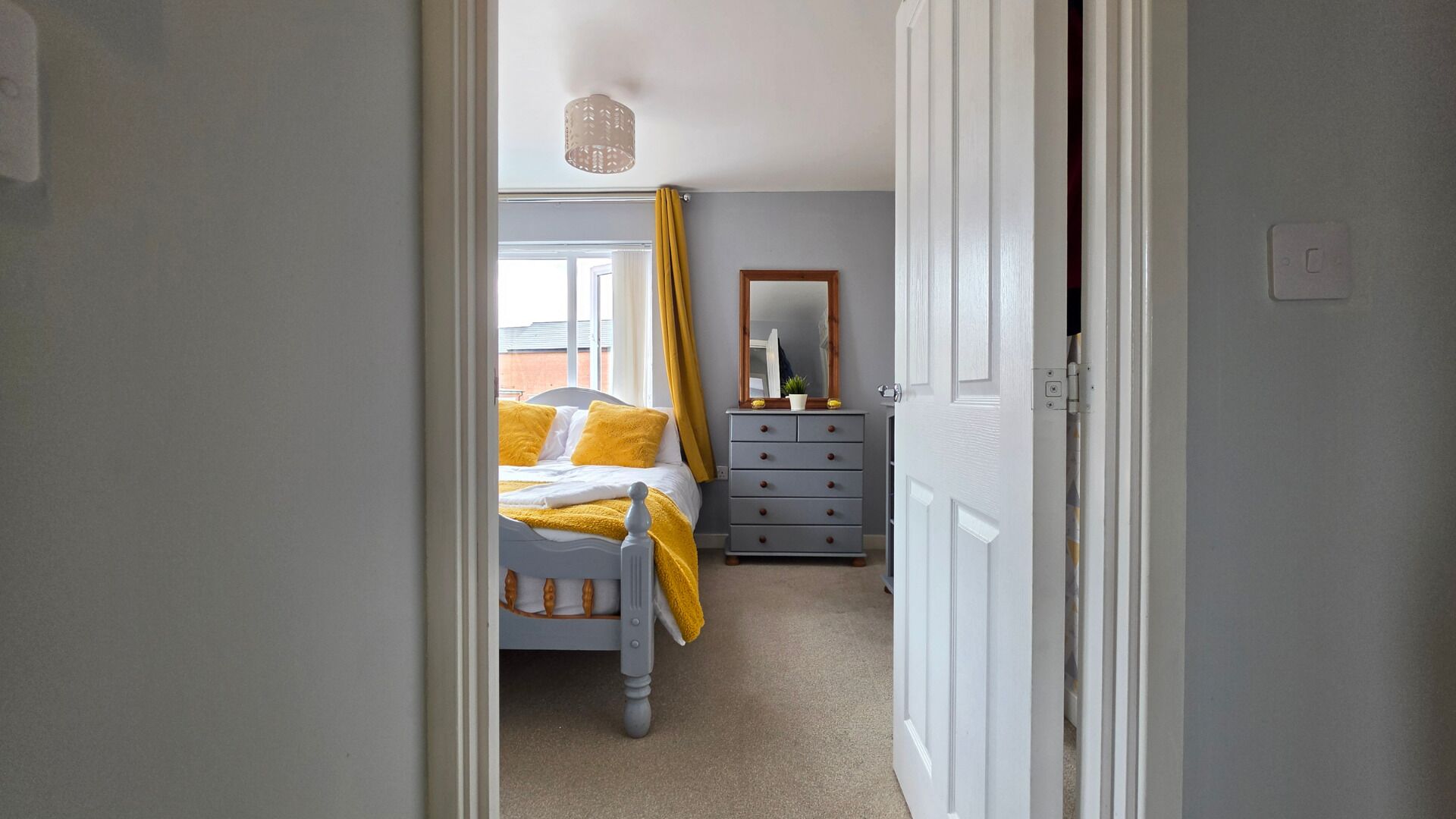 Une chambre à coucher avec un lit, une commode et un miroir.