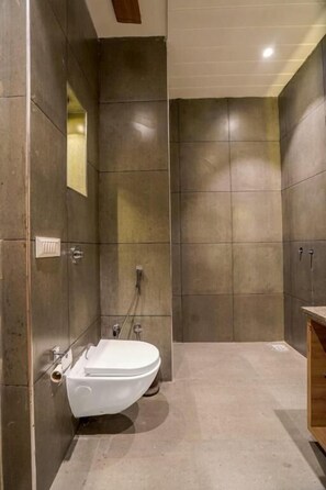 A modern bathroom with a toilet, shower, and sink. - Greenwood Villa (Amritsar)