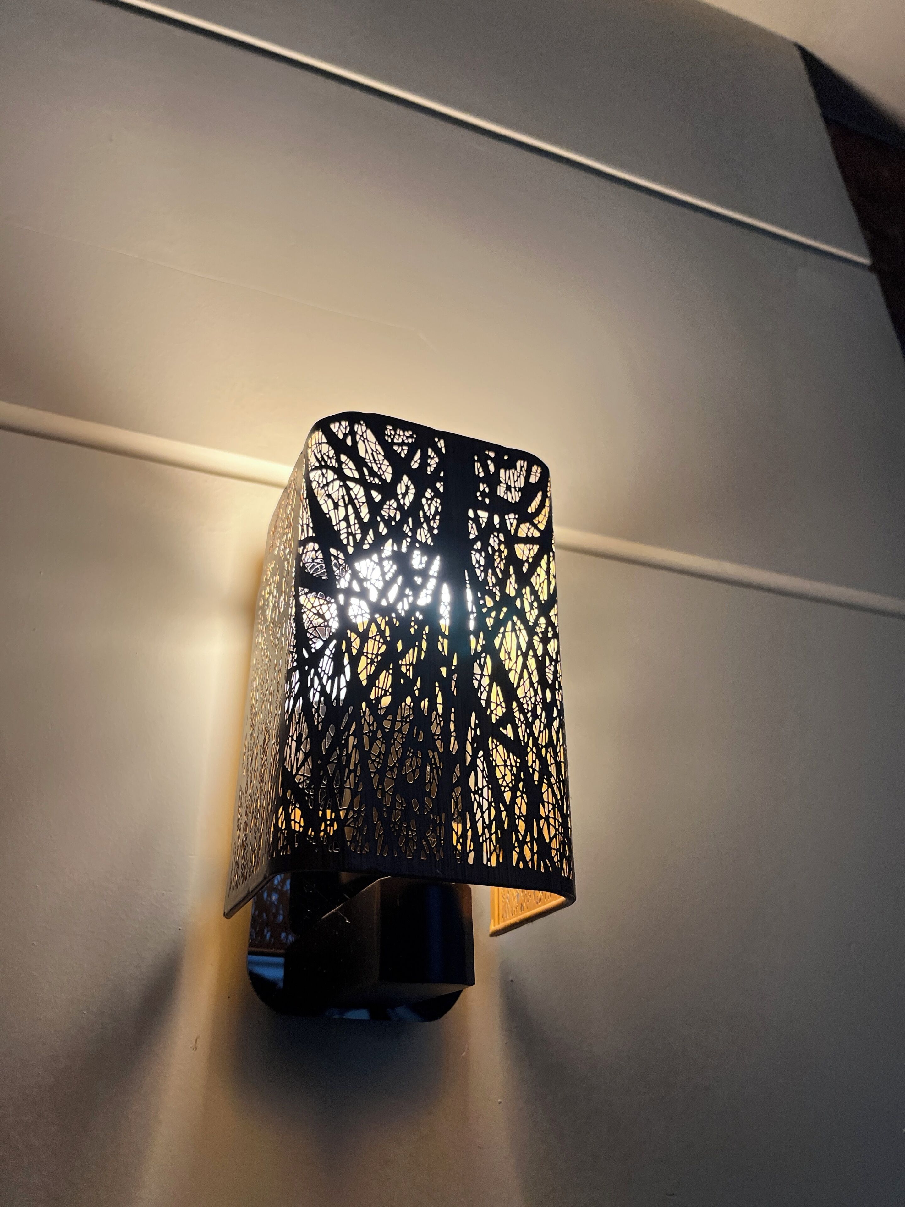 A wall-mounted light fixture with a geometric pattern.
