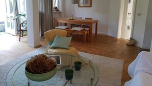 Un salón espacioso con una mesa de comedor, un sofá y una mesa baja de vidrio.