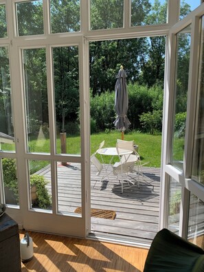 Una veranda con vista su un pontile di legno e mobili da esterno.