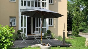 Una casa moderna con un patio, un hogar para fuego y un paraguas grande.