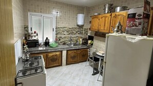 Uma cozinha com fogão, pia, armários e um aquecedor de água.