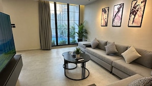 Een moderne woonkamer met een bank, salontafel en televisie.