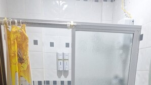 Um banheiro com chuveiro, vaso sanitário e pia.