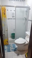 Un baño con ducha, inodoro y lavamanos.