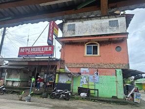 Un bùtiment avec une enseigne indiquant « MHLHILLIER », une autre indiquant « maison de plage » et une troisiÚme indiquant « LBC autorisé ».
