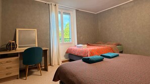 Une chambre à coucher comprenant un lit, un bureau, une chaise, une fenêtre avec des rideaux et un luminaire au plafond.