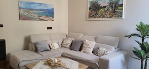 A living room with a sofa, coffee table, and two paintings on the wall. - Adorable little villa in the center of Santa Maria di Leuca (Santa Maria di Leuca)