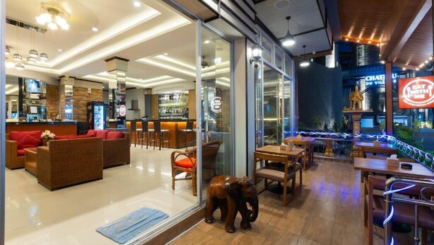 Ein modernes Restaurant mit Bar, Sitzgelegenheiten und einer dekorativen Elefantenskulptur.