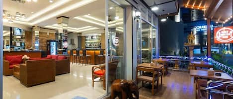 Un restaurante moderno con zona de bar, asientos y una estatua decorativa de un elefante.
