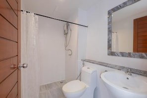 Ein Badezimmer mit Dusche, Toilette und Waschbecken.