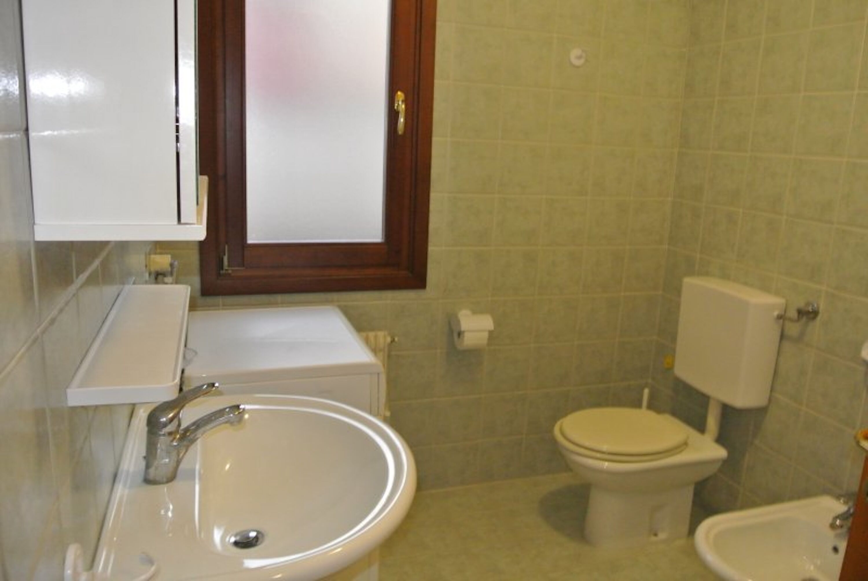 Kylpyhuone, jossa on pesuallas, wc ja bidee.