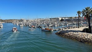A marina with numerous boats docked, a stone breakwater, and a clear blue sky. - 180 Degree Sea Views, Sunny Terrace & Quiet Pool (Luz)