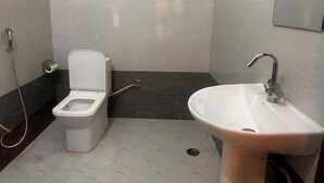 Un baño con inodoro, lavamanos y ducha.
